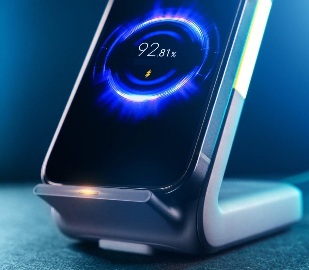 Smartphone apoiado em carregador sem fio com animação luminosa indicando bateria em 92% durante o carregamento.