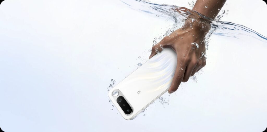 Celular realme 16 5G na cor branca sendo submerso em água. 